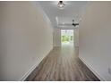 Long hallway with light walls, wood-look flooring, and a view into the living area at 329 Spinney Dr., Little River, SC 29566