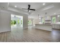 Open concept kitchen with white cabinets, island, stainless steel appliances, and wood-look floors at 329 Spinney Dr., Little River, SC 29566