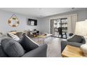 Living room with grey sofas, wood coffee table, and sliding glass door to balcony at 200 Maison Dr. # N-204, Myrtle Beach, SC 29572