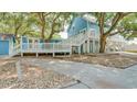 Two story blue house with a deck, stairs, and large trees at 304 2Nd Ave. S, North Myrtle Beach, SC 29582