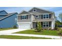 Two-story home with gray siding, white garage door, and landscaped lawn at 263 Lassoed Circle, Murrells Inlet, SC 29576