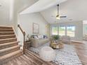 Bright living room with vaulted ceiling, comfy seating, and wood-look floors at 370 Long Meadow Dr., Loris, SC 29569