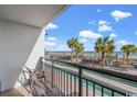 Balcony view of resort pool, palm trees, and ocean at 3000 N Ocean Blvd. # 132, Myrtle Beach, SC 29577