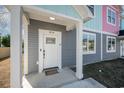 White front door with glass accents, gray siding, and small porch at 503 30Th Ave. N, Myrtle Beach, SC 29577