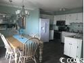 Kitchen and dining area with white cabinets at 5905 S Kings Hwy. # 314-B, Myrtle Beach, SC 29575