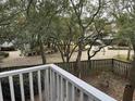 View from balcony showcasing a tree-filled backyard and fence at 178 Salt Marsh Circle # 30F, Pawleys Island, SC 29585