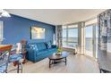 Living room with ocean view, blue sofa, and light wood floors at 2711 S Ocean Blvd. S # 1421, North Myrtle Beach, SC 29582