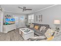 Living room with gray sofa, white coffee table and access to balcony at 6001-5725 S Kings Hwy., Myrtle Beach, SC 29575