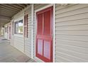 Red door with shutters, on a light beige building at 4305 S Ocean Blvd. # 105, North Myrtle Beach, SC 29582