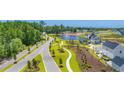 Aerial view of a residential community with roads, a pond, and lush greenery at 2321 Vera Way, Longs, SC 29568