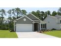 Gray house with white garage door and landscaping at 129 Fair Meadow Ct., Loris, SC 29569