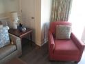 Living room with red armchair and side table at 14290 Ocean Hwy. # 103, Pawleys Island, SC 29585