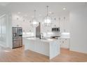 Modern kitchen featuring white cabinets, a large marble island, and stainless steel appliances at 829 Crystal Water Way, Myrtle Beach, SC 29579