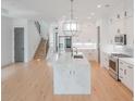 Bright kitchen with white cabinets, marble island, stainless steel appliances, and hardwood floors at 829 Crystal Water Way, Myrtle Beach, SC 29579