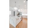 Stylish kitchen with white cabinets, marble island, stainless steel appliances, and hardwood floors at 829 Crystal Water Way, Myrtle Beach, SC 29579