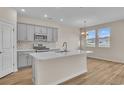 Modern kitchen with gray cabinets, white quartz island, and stainless steel appliances at 3009 Deerberry Place, Longs, SC 29568