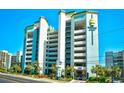 Oceanfront building exterior with parking garage and palm trees at 6804 N Ocean Blvd. # 1409, Myrtle Beach, SC 29572