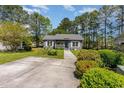 Gray house with white shutters, walkway, and manicured lawn at 1302 Conifer Ct., Murrells Inlet, SC 29576