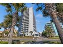Oceanfront building exterior with palm trees and ample parking at 5511 N Ocean Blvd. # 1106, Myrtle Beach, SC 29577