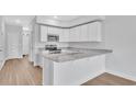 Modern kitchen with white cabinets and granite countertops at 301 Sandridgebury Dr. # 68, Little River, SC 29566