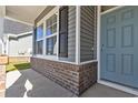 New home exterior showcasing gray siding, brick accents, and a blue front door at 2461 Campton Loop, Conway, SC 29527