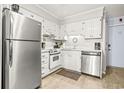 Small kitchen with white cabinets and stainless steel appliances at 5001 N Ocean Blvd. # 3-E, North Myrtle Beach, SC 29582