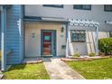 Townhouse entrance with a red door and landscaping at 775 Plantation Dr. # 88, Little River, SC 29566