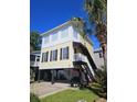 Two-story beach house with a yellow exterior, white trim, and black shutters at 5226 Highway 17 Business, Murrells Inlet, SC 29576