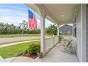 Covered front porch with white railings and American flag at 1433 Beaumont Way, Myrtle Beach, SC 29577