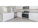 Modern kitchen featuring stainless steel appliances and white cabinets at 1932 Whispering Pine St., Ocean Isle Beach, NC 28469