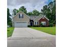 Tan brick house with a two-car garage and landscaping at 173 Rocko Dr., Myrtle Beach, SC 29579