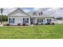 Front view of a charming house with gray siding, blue shutters, and a green lawn at 268 Maple Oak Dr., Conway, SC 29526