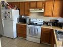 Kitchen with wood cabinets, appliances, and tile floor at 1025 Carolina Rd. # M-3, Conway, SC 29526
