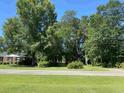 Ranch house with a spacious yard, mature trees, and a tree-lined street at 4155 Pinewood Dr., Mullins, SC 29574
