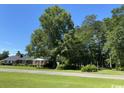 Brick house with mature trees and a large yard at 4155 Pinewood Dr., Mullins, SC 29574