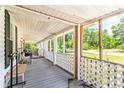 Long wooden front porch with white railings, offering a relaxing outdoor space at 406 N Nichols St., Nichols, SC 29581