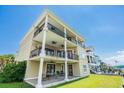 Tan three-story house with large balconies and patio at 181 Palmetto Harbour Dr., North Myrtle Beach, SC 29582