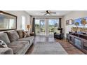 Bright living room with hardwood floors, sliding doors to balcony, and comfortable seating at 1100 Possum Trot Rd. # C-101, North Myrtle Beach, SC 29582