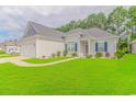 Gray house with a white garage and landscaped lawn at 1616 Sapphire Dr., Longs, SC 29568