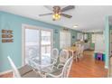 Dining area with glass table, white chairs and view into the kitchen at 6001- 1029 S Kings Hwy., Myrtle Beach, SC 29575