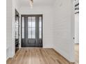 Elegant entryway with dark gray door, hardwood floors, and white shiplap walls at 851 Waterton Ave., Myrtle Beach, SC 29579