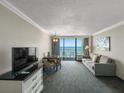 Living room features a sofa, TV, and dining area with ocean view at 1105 S Ocean Blvd. # 1204, Myrtle Beach, SC 29572