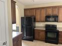 Modern kitchen featuring dark wood cabinets, black appliances, and ample counter space at 3609 White Oleander Ct., North Myrtle Beach, SC 29582
