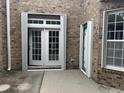 Home's exterior showcasing a brick facade, hurricane shutters, and a patio area at 3609 White Oleander Ct., North Myrtle Beach, SC 29582