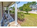 Front porch with chairs and view of a tree-lined street at 2009 Spring Valley Ct., Loris, SC 29569