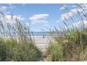 Path through beach grass leading to a sandy beach and ocean at 4303 S Ocean Blvd. # 107, North Myrtle Beach, SC 29582