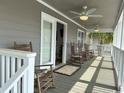 Relaxing covered porch with rocking chairs and ceiling fan at 1521 N Waccamaw Dr., Murrells Inlet, SC 29576