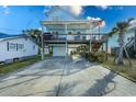 Elevated beach home with a light blue exterior, a porch, and a spacious driveway at 410 22Nd Ave. N, North Myrtle Beach, SC 29582