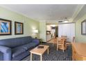 Living room with a blue sofa and a view into the kitchen at 2201 S Ocean Blvd. # 1505, Myrtle Beach, SC 29577