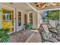 Inviting front porch with brick flooring, yellow door, and seating area at 366 Lakeshore Dr., Pawleys Island, SC 29585